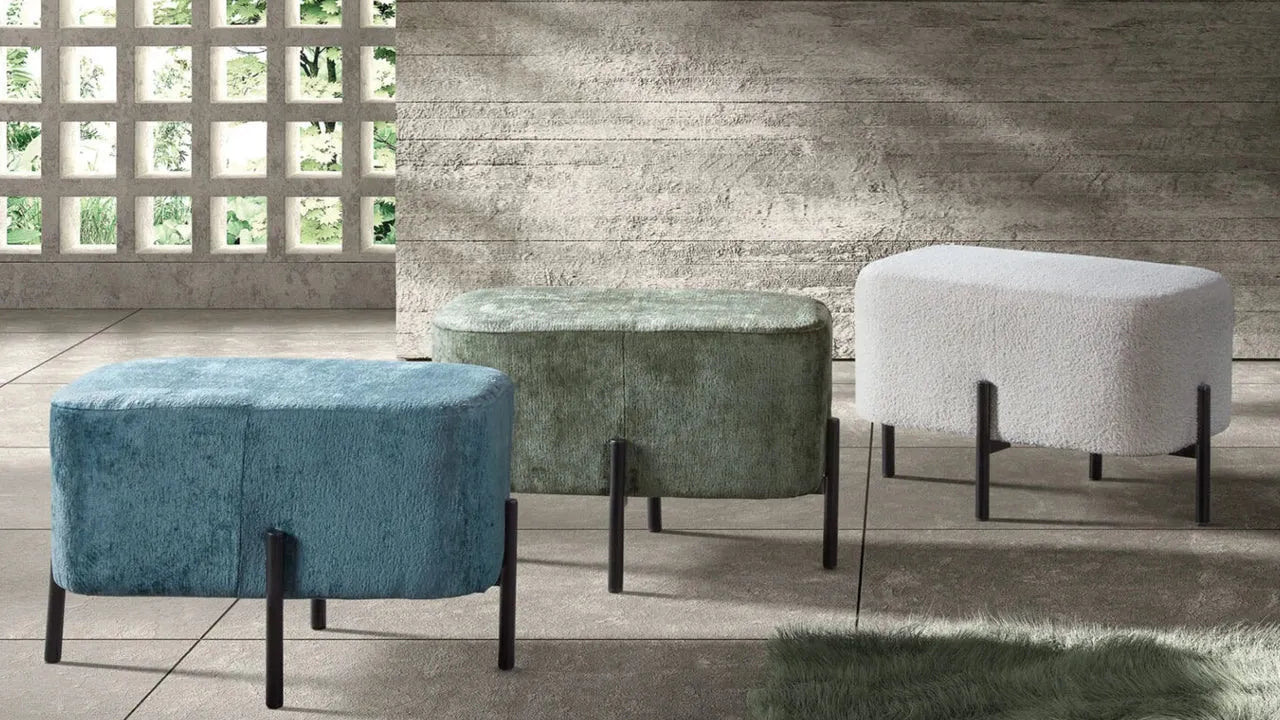 Drei gepolsterte Hocker in Blau, Grün und Weiß mit schwarzen Metallbeinen in modernem Raum