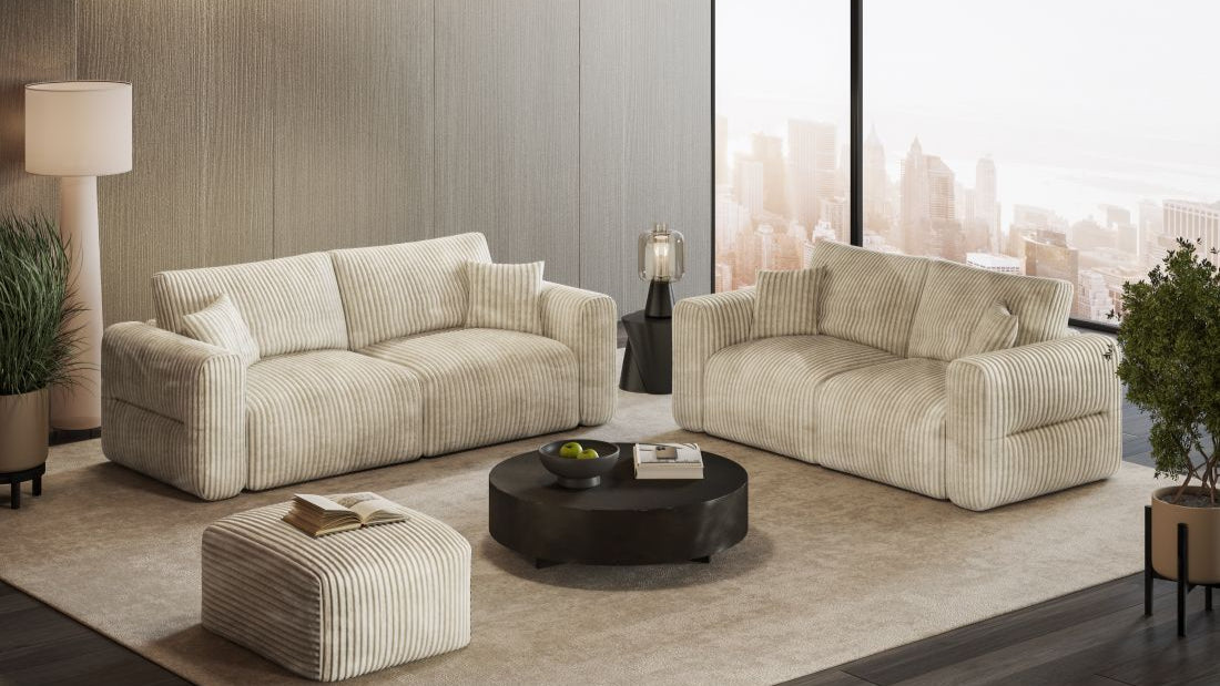 Wohnzimmer mit zwei gestreiften Sofas, Hocker und rundem Couchtisch vor großer Fensterfront mit Stadtblick.