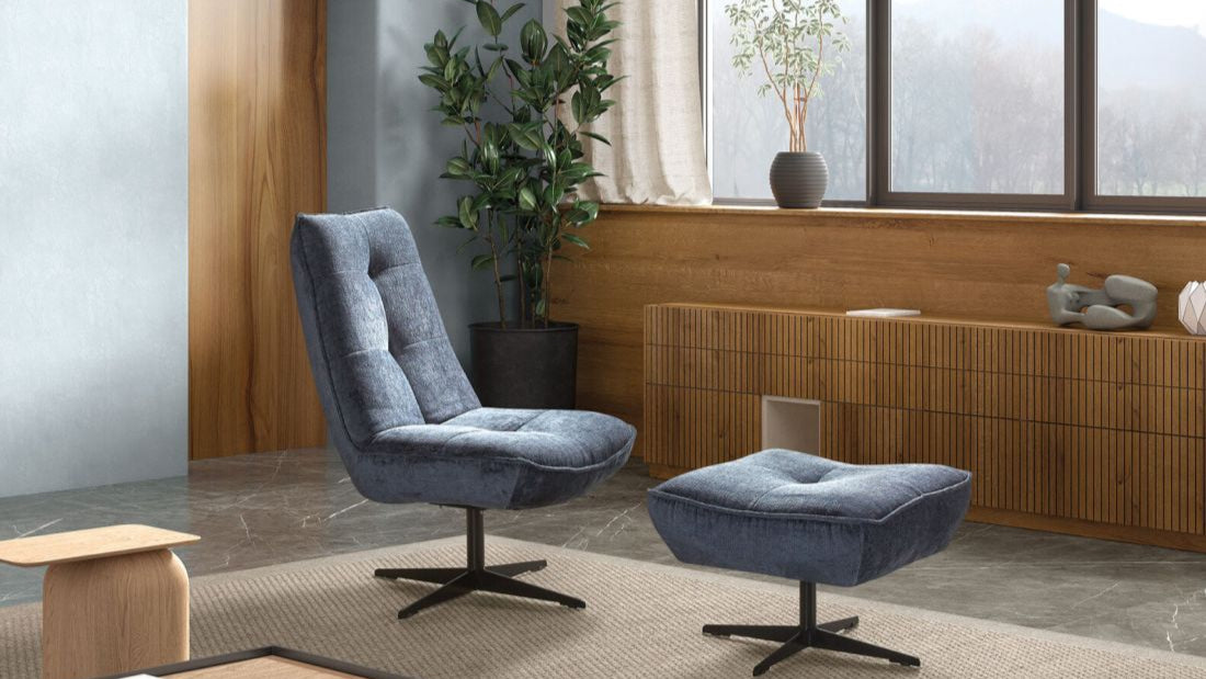 Blauer Loungesessel mit passendem Hocker in modernem Wohnraum.