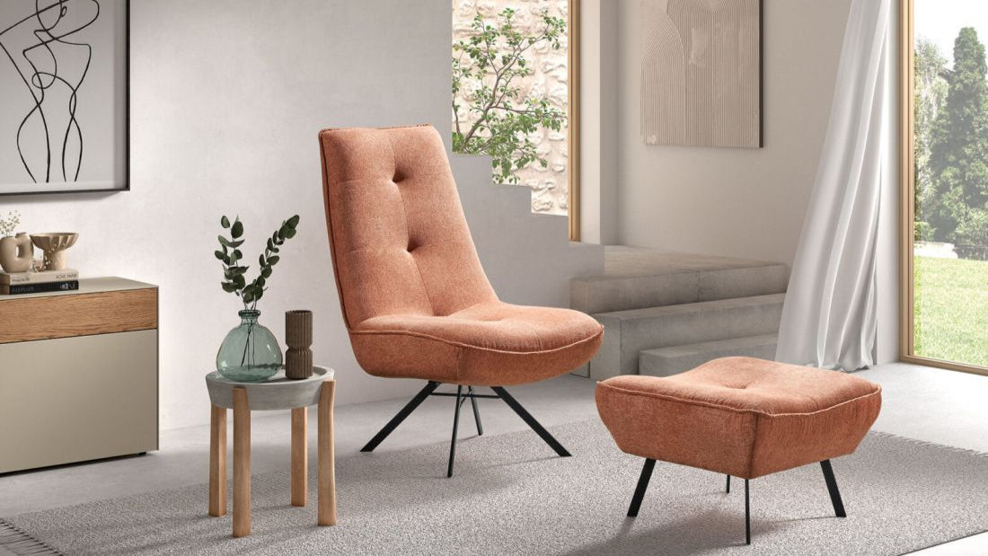 Oranger Loungesessel mit passendem Hocker in modernem Wohnraum.