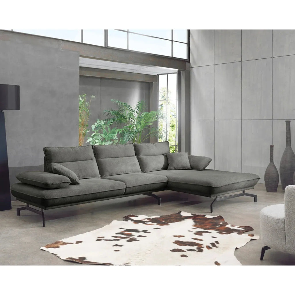 Modernes graues Ecksofa mit Kissen in stilvollem Wohnraum mit Pflanzen