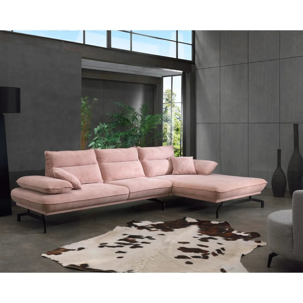 Modernes rosafarbenes Ecksofa mit Kissen in stilvollem Wohnraum mit Pflanzen