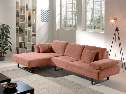 Modernes roséfarbenes Ecksofa mit Kissen in hellem Wohnzimmer mit Regal und Stehlampe
