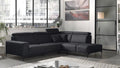 Modernes schwarzes Ecksofa mit Kissen in hellem Wohnraum mit großen Fenstern