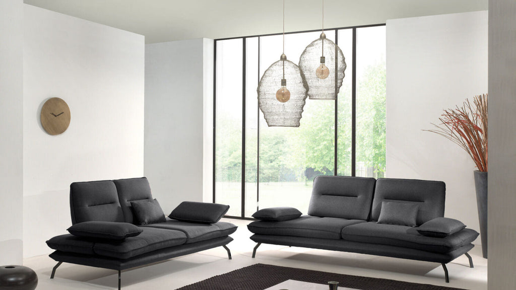 Modernes schwarzes Sofa-Set mit verstellbaren Rückenlehnen in hellem Wohnzimmer vor großer Fensterfront