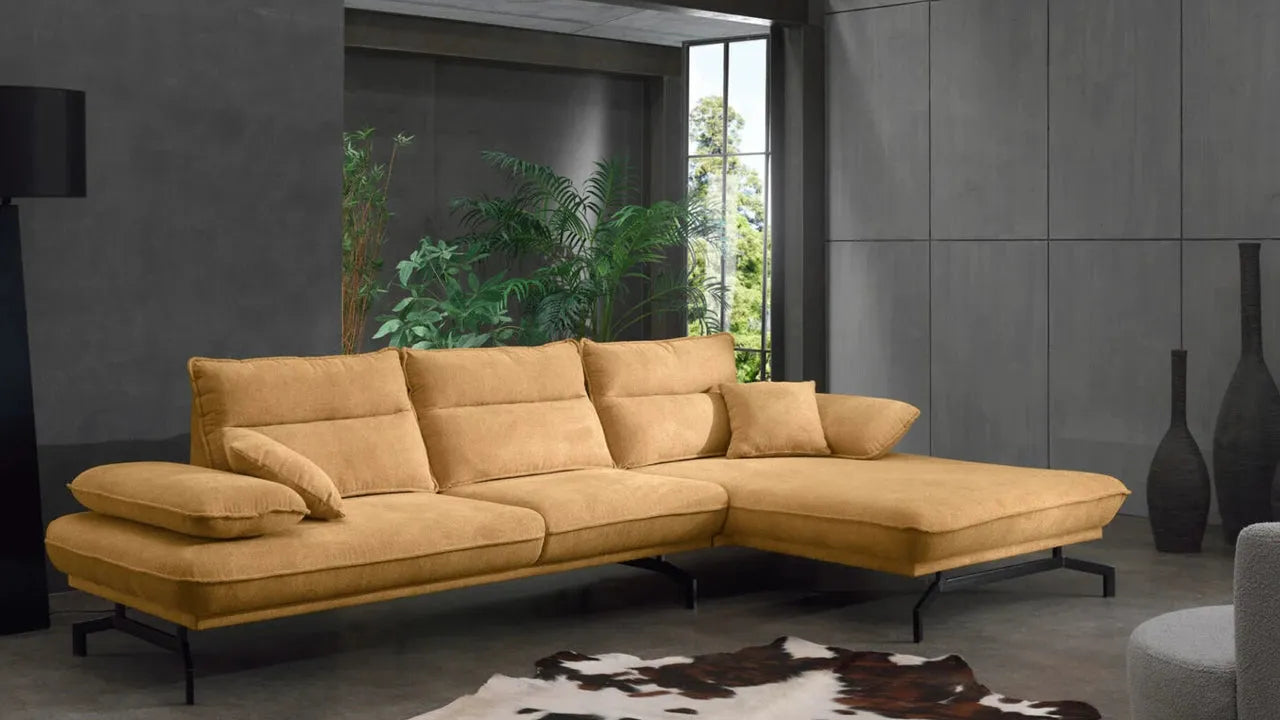 Modernes senffarbenes Ecksofa mit Kissen in stilvollem Wohnraum mit Pflanzen