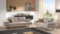 Modernes Wohnzimmer mit zwei beigen Sofas, Zierkissen und großer Fensterfront