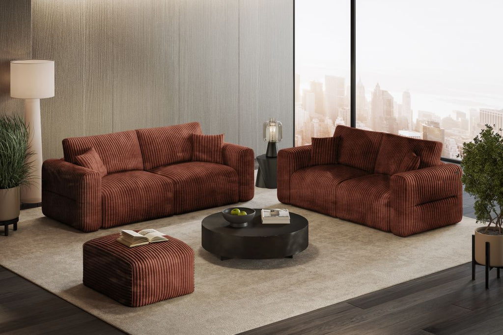 Wohnzimmer mit zwei roten gestreiften Sofas, Hocker und rundem Couchtisch vor großer Fensterfront mit Stadtblick.